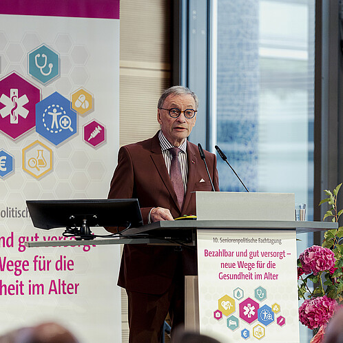 Ein Mann steht hinter einem Rednerpult und spricht in das Mikrofon