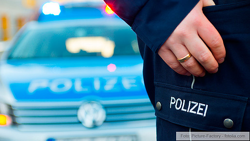 Polizist vor Polizeiauto