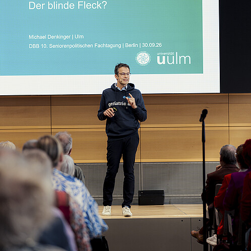 Ein Mann steht auf einer Bühne und hält einen Vortrag