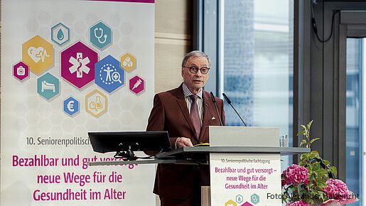 Ein Mann steht hinter einem Rednerpult und spricht in das Mikrofon