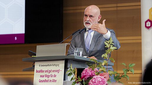 Ein Mann steht hinter einem Rednerpult und spricht in das Mikrofon