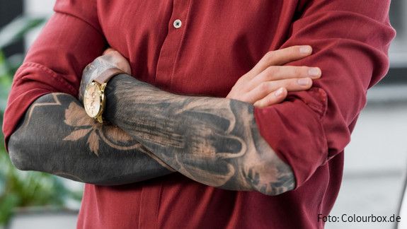 Tätowiert … war’s das mit der Verbeamtung? ein tätowierter mann lächelt in die kamera