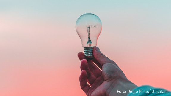 Glühbirne im Licht Eine Glühbirne wird ins Licht gehalten