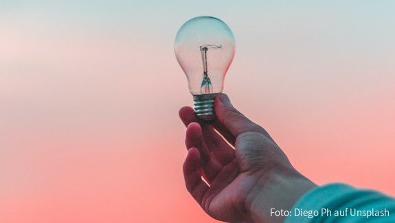 Eine Glühbirne wird ins Licht gehalten