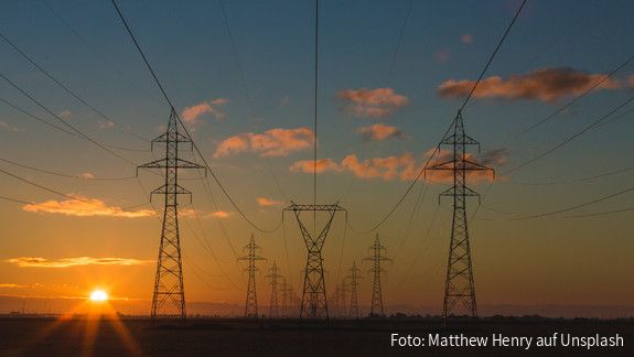 Stromleitungen und Strommasten in der Morgendämmerung