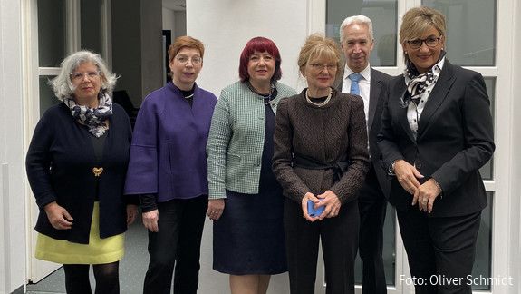 Sechs Personen stehen nebeneinander und lächeln in die Kamera