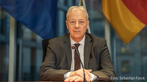 Markus Töns, MdB Markus Töns sitzt vor der deutschen und europäischen Flagge