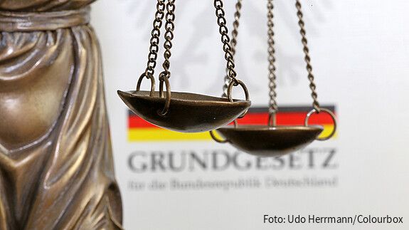 Tag des Grundgesetzes Nahaufnahme einer Justitia vor dem deutschen Grundgesetzbuch