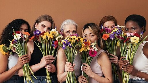 Eine Gruppe diverser Frauen halten Blumensträuße in der Hand