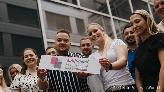 Zu sehen sind Mitglieder der dbb jugend mit einem Schild, auf dem "dbb jugend" steht.