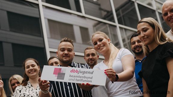 Zu sehen sind Mitglieder der dbb jugend mit einem Schild, auf dem "dbb jugend" steht.