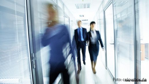 Verwaltung der Zukunft Menschen gehen durch ein Glasgebäude