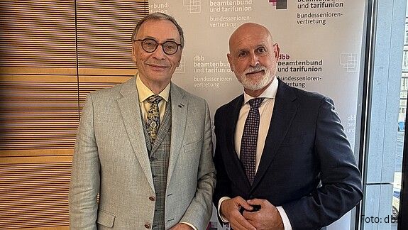 Volker Geyer und Dr. Horst Günther Klitzing stehen nebeneinander vor einem Roll-up der dbb bundesseniorenvertretung.