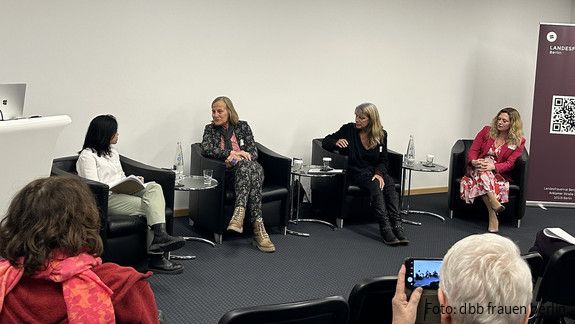 Vier Frauen sitzen auf Stühlen und diskutieren miteinander