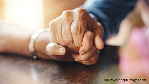 Zwei berührende Hände auf einem Tisch